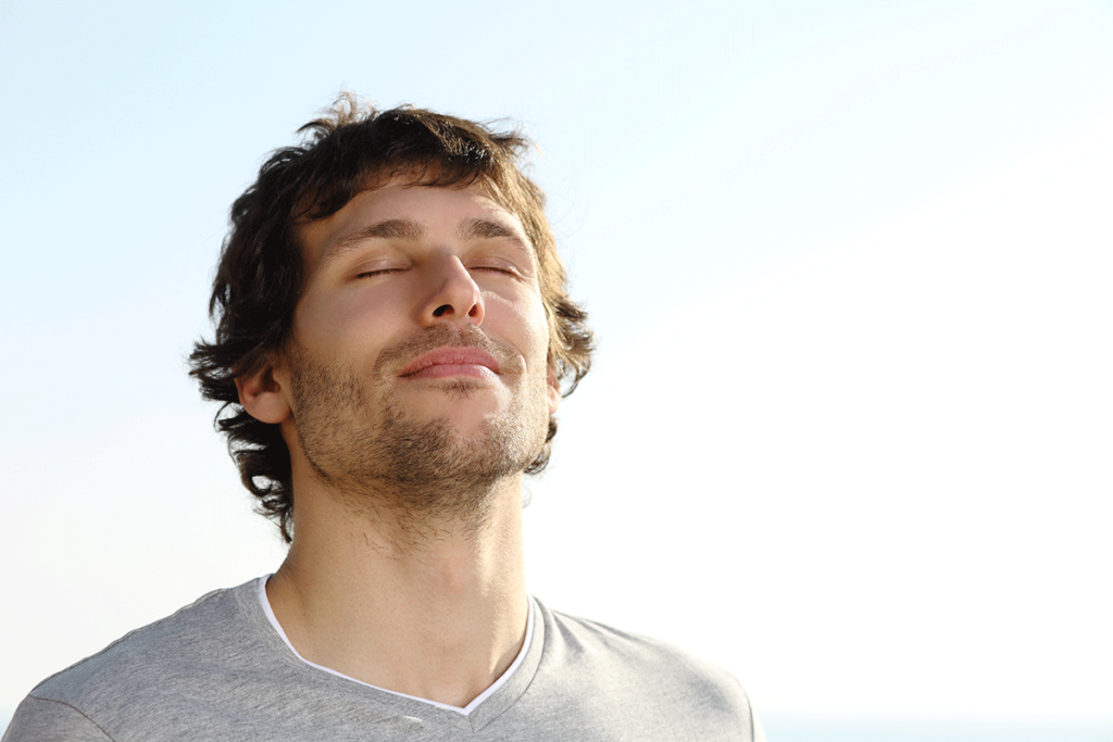 man closes his eyes and embraces the sunshine after utilizing some dbt techniques for his depression