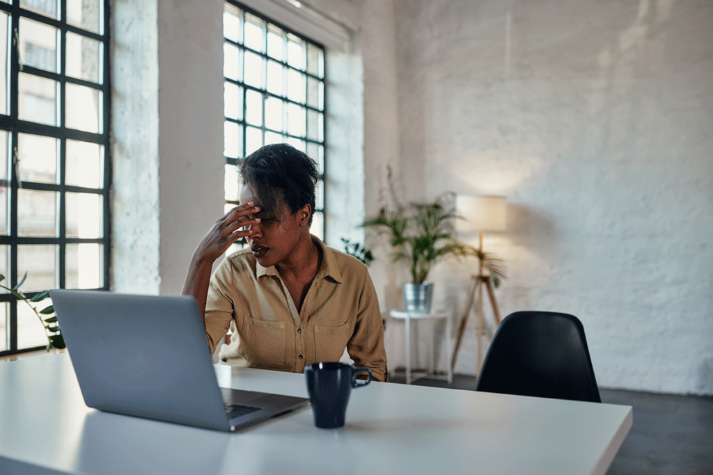 A woman experiences difficulty focusing on her work; one of the signs of ADHD.