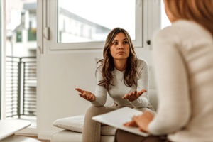 A woman is discussing her alcohol use disorder with a therapist.